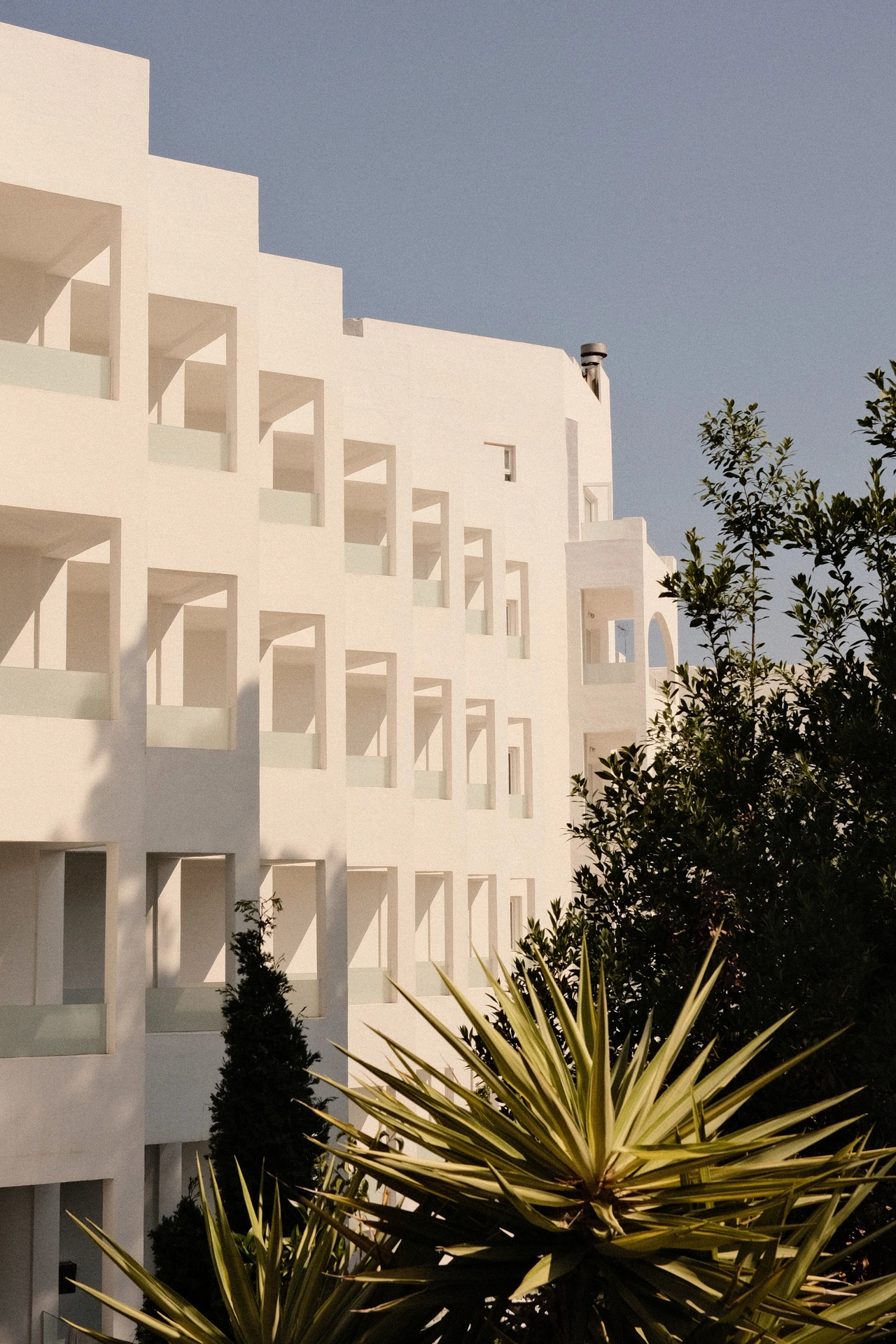Sunlight and shadow across white geometric balconies