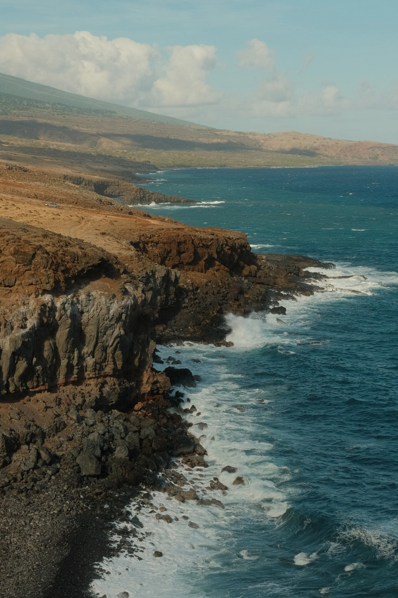 A rugged volcanic shoreline beside deep blue water
