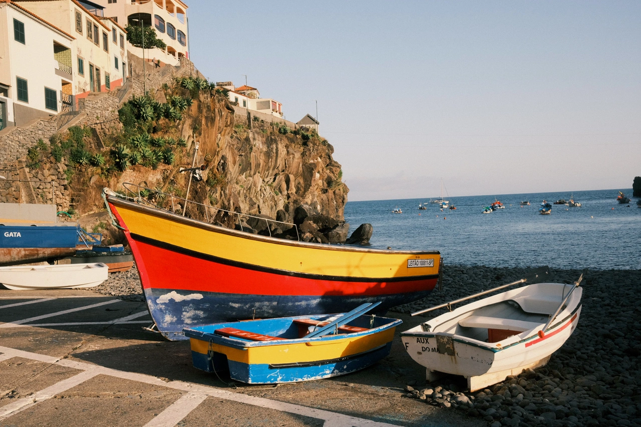 Bright wooden fishing boats beneath a cliffside village