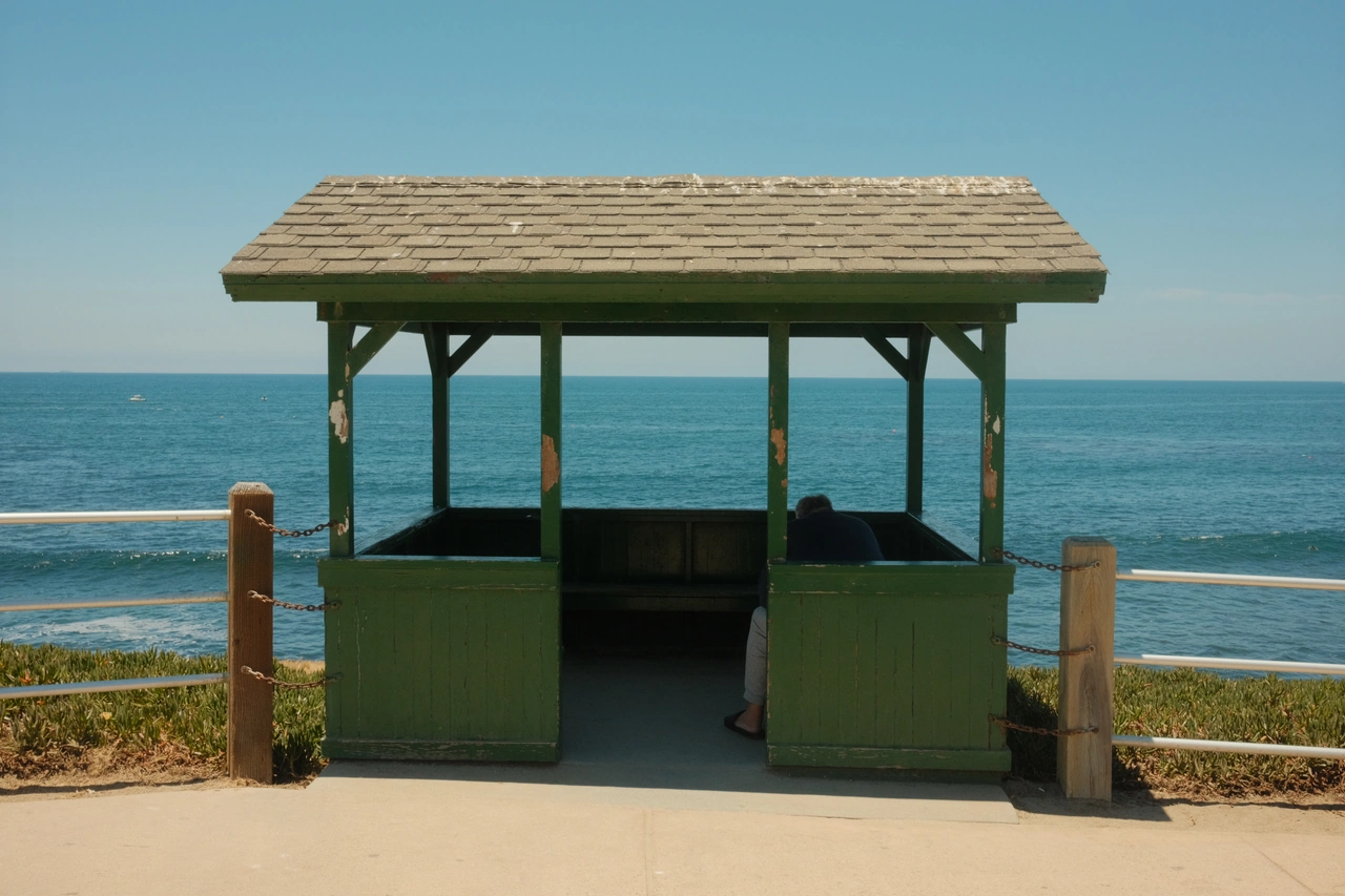 A pale green seaside shelter against a blue horizon