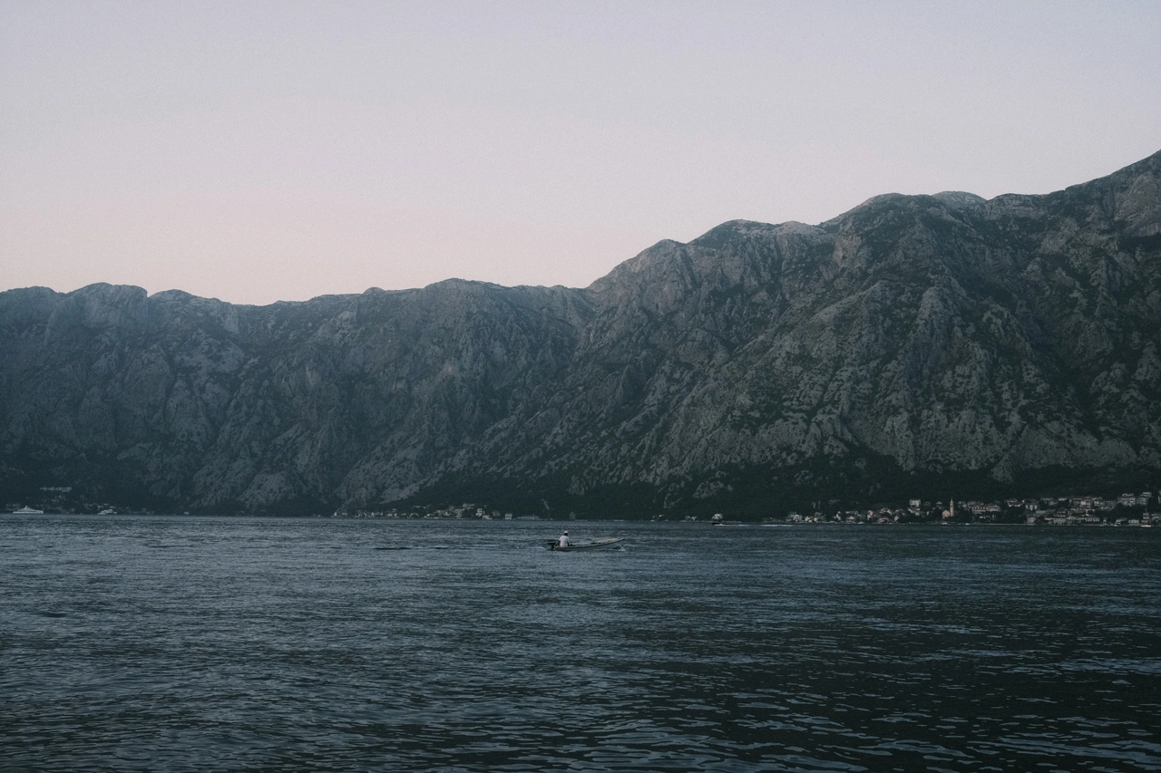 A pale mountain ridge above dark, rippling water